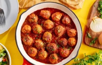 Albóndigas caseras en salsa putanesca servidas en una sartén con cebollas y cilantro Albóndigas caseras en salsa putanesca servidas en una sartén con cebollas y cilantro