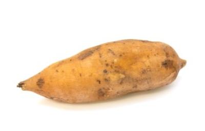 Camote, la papa dulce. Un camote sin pelar en fondo blanco.