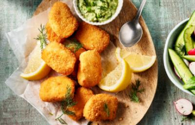 Chicharrón de pollo con salsa verde y limón Trozos de chicharrón de pollo crujiente servidos con salsa verde, rodajas de limón y ensalada fresca