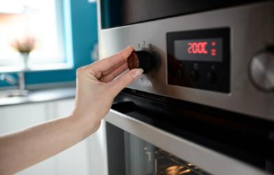 Persona ajustando temperatura en horno, termómetro de cocina
