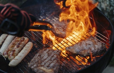 Carnes y chorizos ahumados cocinados a la parrilla a fuego alto.