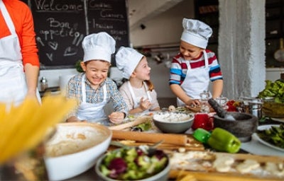 Tres niños preparando recetas alegremente.