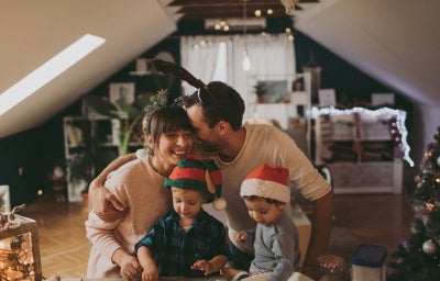 Familia reunida cocinando galletas durante una novena de Navidad para niños.