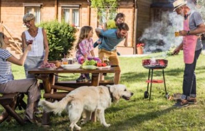 Familia reunida cocinando carne a la parrilla al aire libre.