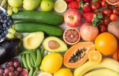 Variedad de vegetales y frutas bajas en azúcar frescas sobre una mesa de madera.