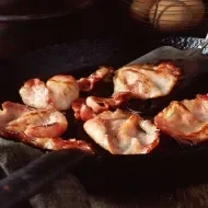 Tocineta siendo cocinada en una sartén.