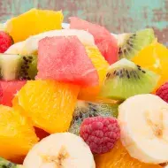 Ensalada de frutas con banano, naranja, sandía y frambuesas
