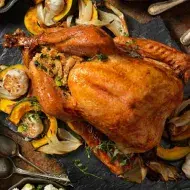 Un jamón de pavo acompañado de diferentes guarniciones navideñas. 