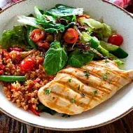 Un pollo marinado, acompañado de ensalada 