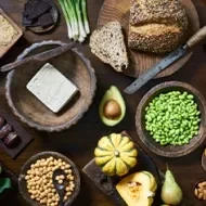Tofu, granos, semillas y verduras servidas en una mesa, comidas veganas que se suelen usar