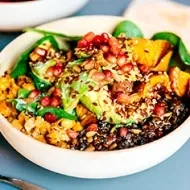 Granos, semillas, frutas y verduras en un plato de comida vegetariana.