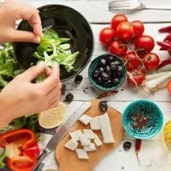 Aceite de oliva, queso, frutas cítricas y tomates para una ensalada griega, una comida mediterránea.