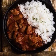 Carne en cuadros y arroz blanco en una sartén de hierro