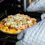 Sacar receta del horno utilizando guantes y agarraderas de cocina 