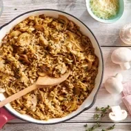 Arroz con champiñones en plano cenital en una vasija blanca, uno de los tipos de arroz.