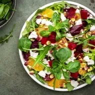 Ensalada en cenital con hojas verdes, remolacha, queso y frutos cítricos, un plato que puedes conservar en casa