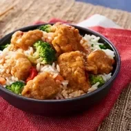 Pollo a la naranja con palillos y arroz, uno de los platos de sabor dulce y amargo más conocidos en el mundo
