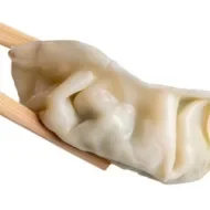 Gyoza de camarón tomada con palillos.