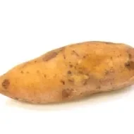Un camote sin pelar en fondo blanco.