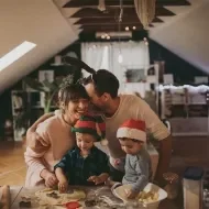Familia reunida cocinando galletas durante una novena de Navidad para niños.