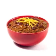 Tazón de chili con carne y queso rallado derretido sobre fondo rojo vibrante.