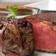 Corte de carne cocido al término medio con centro rojo y jugoso.