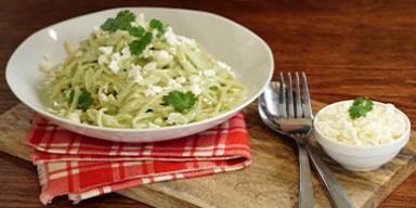 Pasta aromatizada con cilantro, servida en un plato blanco. Pasta aromatizada con cilantro, servida en un plato blanco.