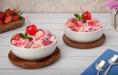 Copas de fresas con crema de vainilla NUTREN Senior, ralladura de naranja y menta, servidas frías