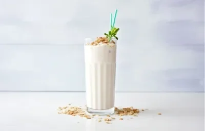 Avena helada cremosa con NUTREN® Senior vainilla, servida en vaso alto, con hielo, canela y hojuelas de avena