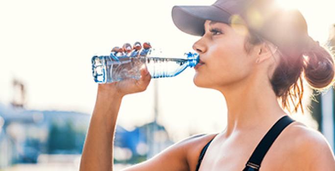 Mujer tomando agua fundamental antes de hacer ejercicio Mujer tomando agua fundamental antes de hacer ejercicio