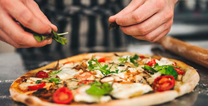La pizza, los quesos y las pastas son muy importantes en el turismo gastronómico de Italia Una pizza italiana tradicional con verduras y queso, un atractivo del turismo gastronómico.