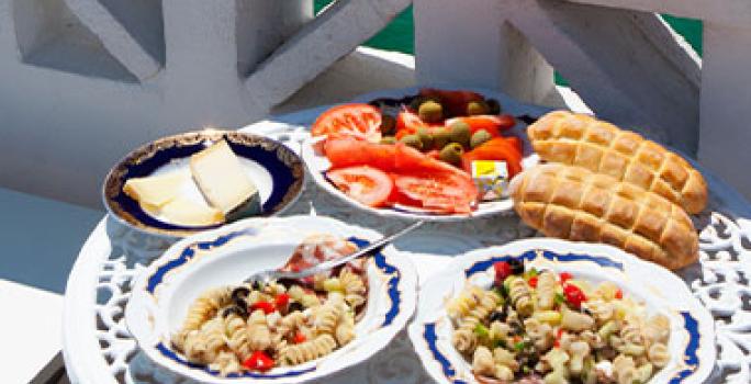 El turismo gastronómico es popular en todos los continentes. Una mesa con dos platos servidos y con vista al mar, una posibilidad del turismo gastronómico.