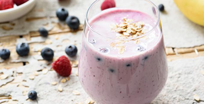 Vaso con batido de frutos rojos para beber antes de hacer ejercicio Vaso con batido de frutos rojos para beber antes de hacer ejercicio
