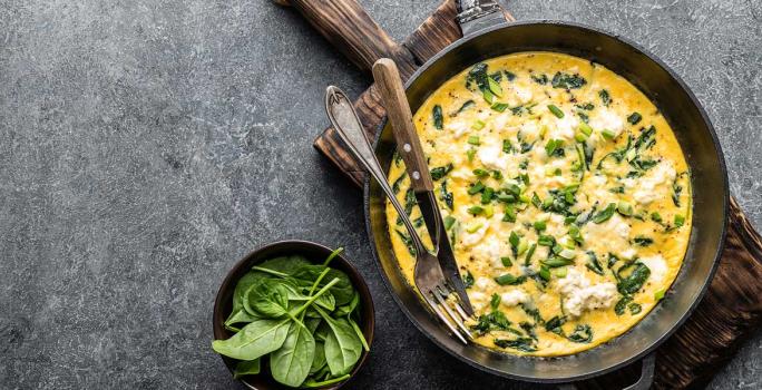 Huevos revueltos y espinaca cremosa sobre arepa