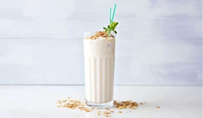 Avena helada cremosa con NUTREN® Senior vainilla, servida en vaso alto, con hielo, canela y hojuelas de avena