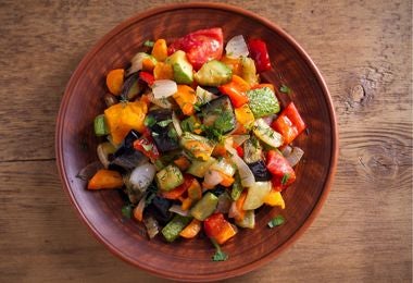 Varios vegetales encurtidos servidos en plato de bambú.